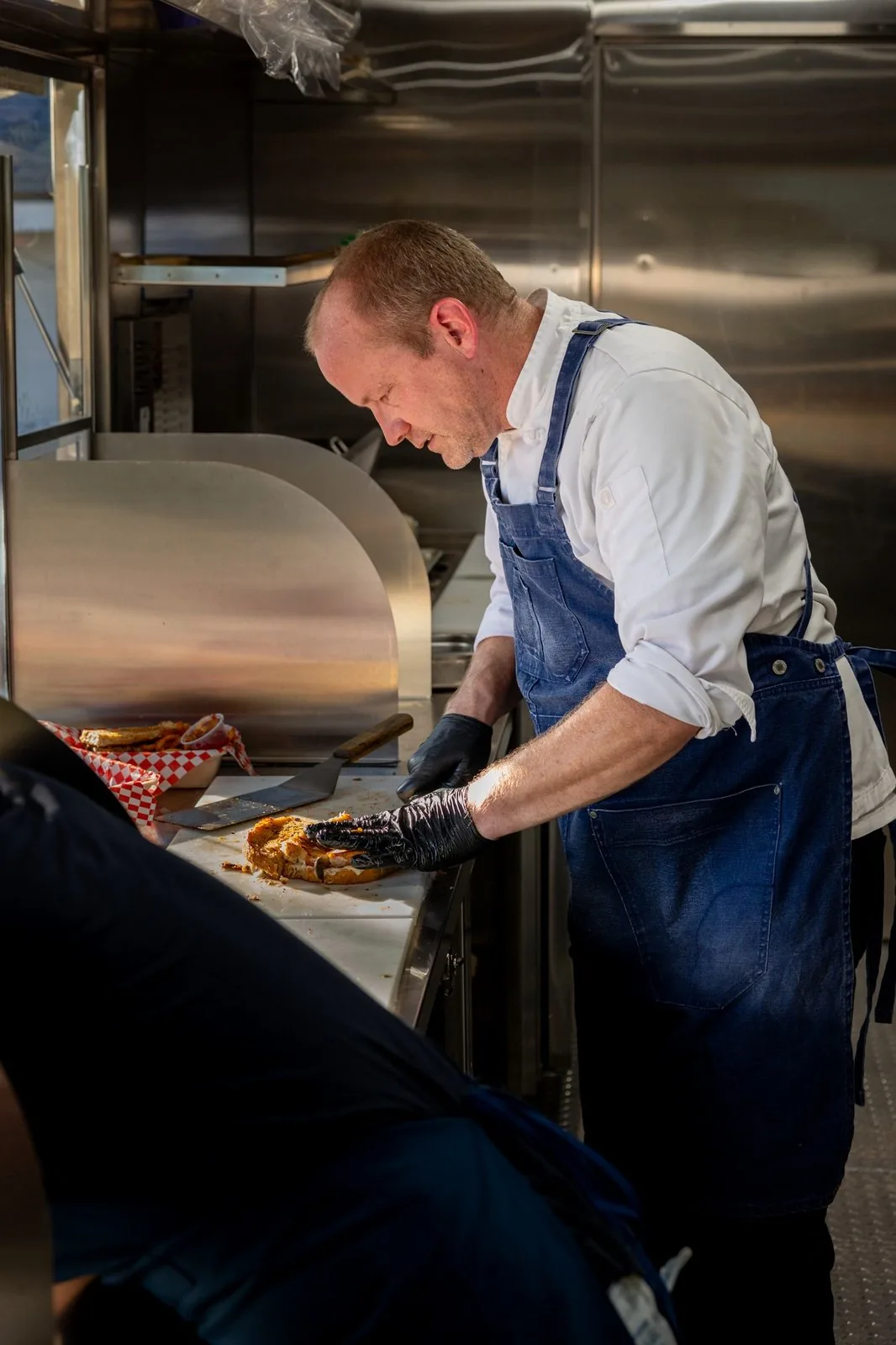 Chef Natale Koch pressing sandwiches on the line inside the HWYCAFE truck